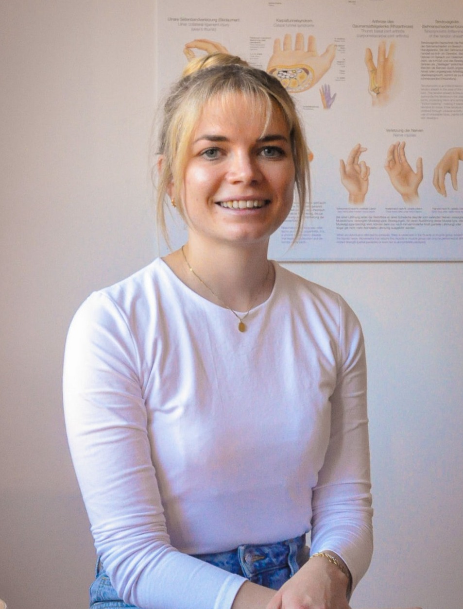 Portrait noch Lena Frank vor einem Anatomieposter der Hand