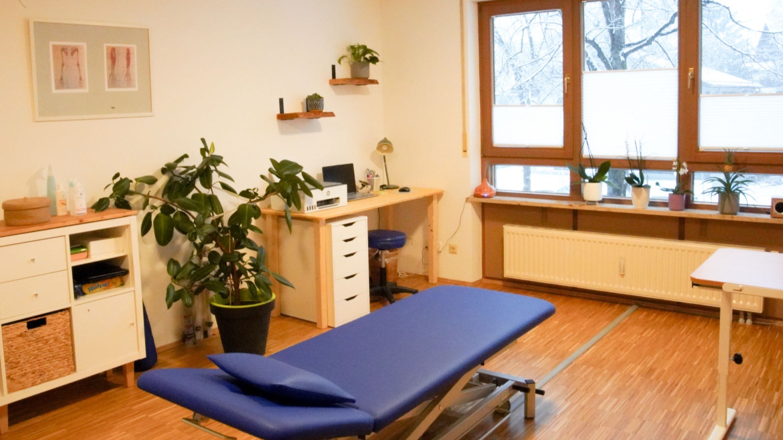 Behandlungsraum der Ergotherapie Frank mit Therapieliege und Arbeitsbereich