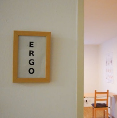 Wandbild mit Schriftzug ERGO am Eingang zum Behandlungsraum