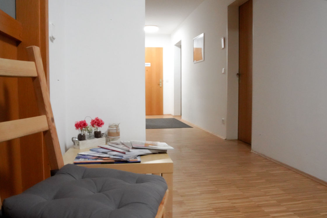 Heller, ruhiger Flur der Ergotherapiepraxis mit Sitzgelegenheit